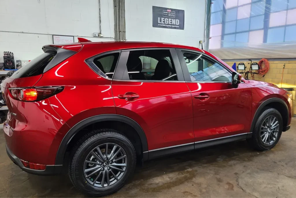 Red car with glossy finish inside a detailing shop