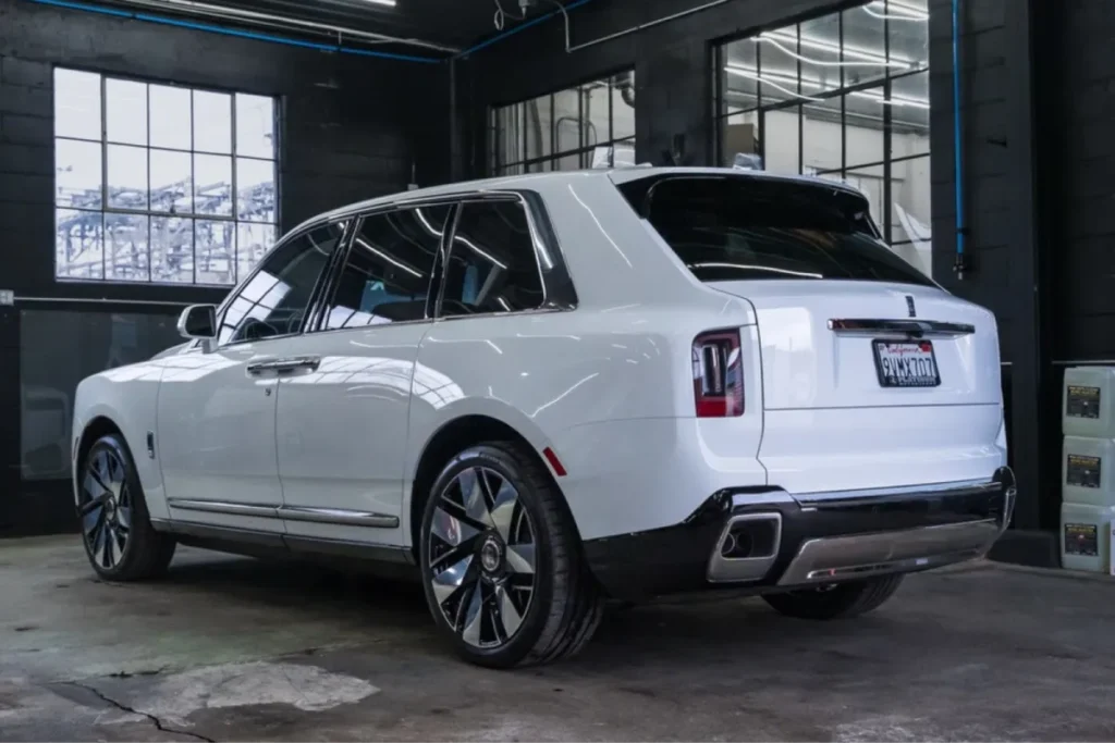 White Rolls Royce Cullinan SUV inside detailing shop with glossy finish