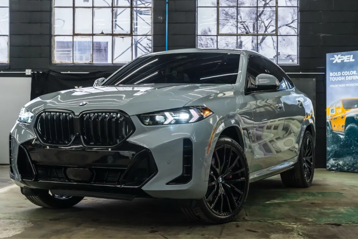 A car with black wheels and tinted windows parked inside a garage.