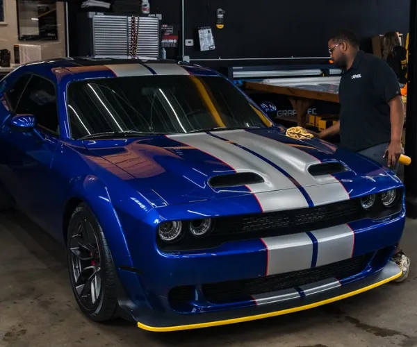 Blue Dodge Challenger receiving professional car detailing service.