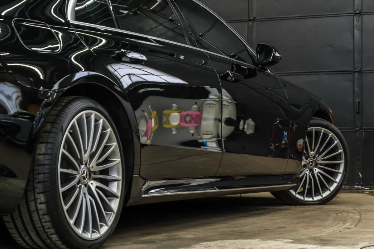 Ceramic coated black Mercedes sedan with mirror like reflections.