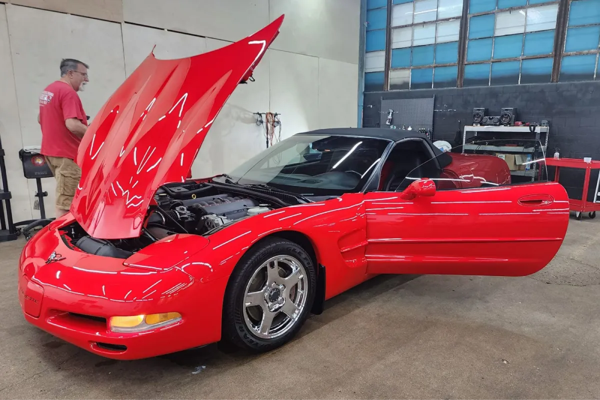 Red Corvette undergoing professional paint correction.
