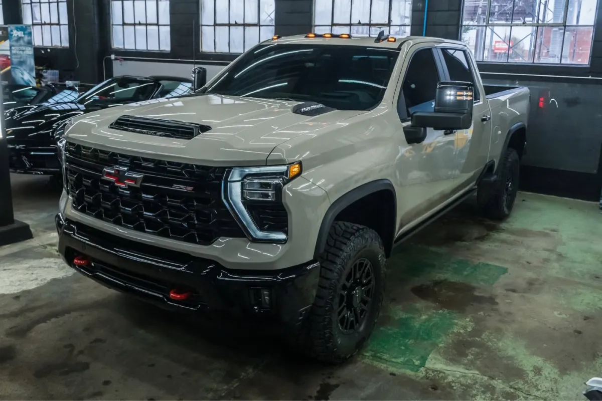 Chevrolet truck with dark window tint inside a shop.