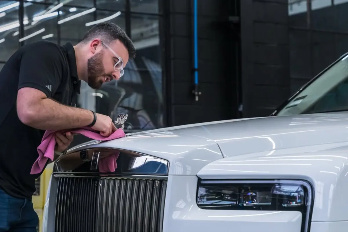 Professional car detailing on a white Rolls Royce exterior.