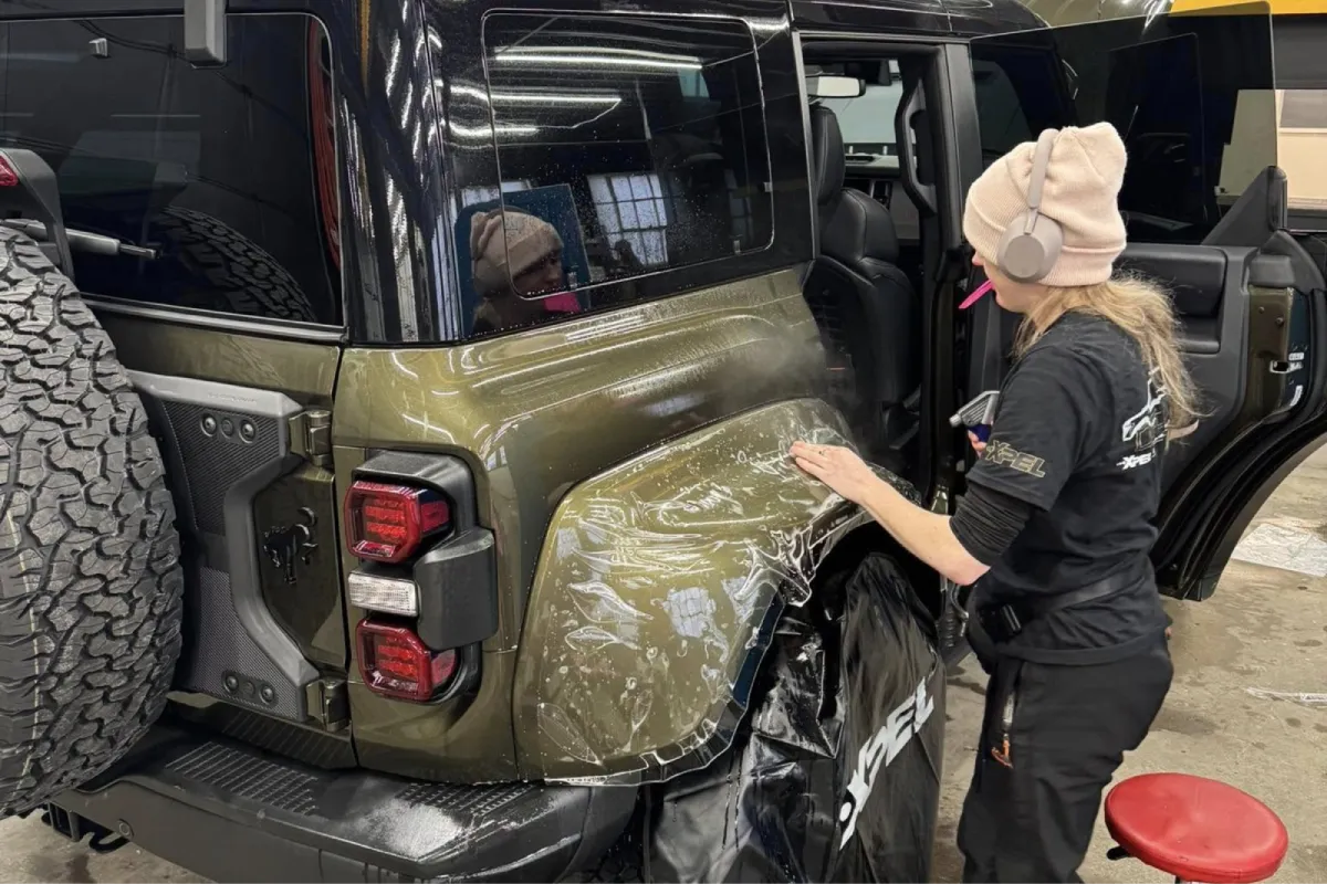 Jeep with paint protection film being applied to the rear fender.